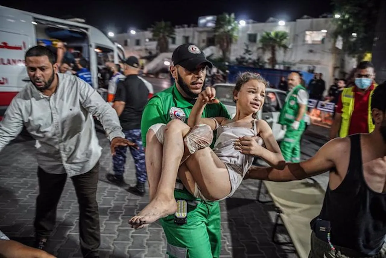 Un paramédico con una niña palestina en brazos en el lugar de un bombardeo durante el mes de octubre. Gaza / Foto: EP