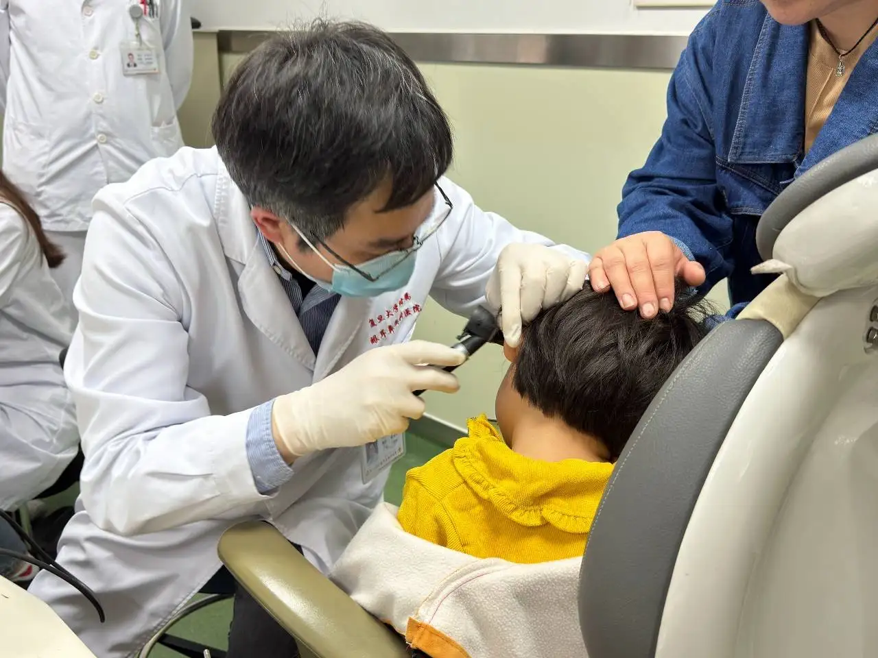 Nueva terapia génica devuelve la audición y el habla a niños sordos. El investigador Yilai Shu examina a un niño / Foto: Universidad de Fudan