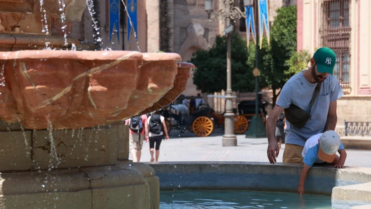 Unas personas se refresca en una fuente para soportar las altas temperaturas. A 10 de agosto de 2024, en Sevilla (Andalucía, España) / Foto: EP