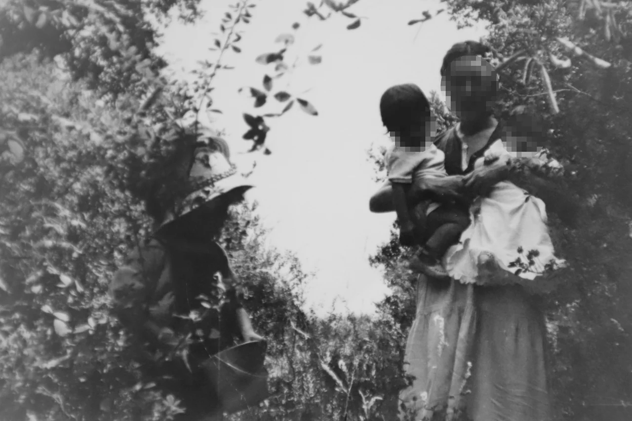 Una mujer perteneciente a la "comuna Vida Sana" sostiene a dos bebés nacidos en el seno de la misma / Foto: FA