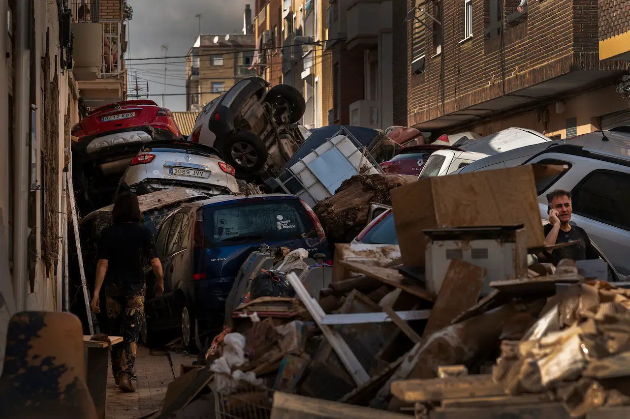 Coches apilados por la fuerza del agua en una de las calles de Alfafar, lo que impidió a muchos vecinos salir o entrar a sus casas hasta que fueron retirados. Este efecto embudo se repitió en muchas de las calles más estrechas de las poblaciones afectadas / Foto: Alfons Rodríguez